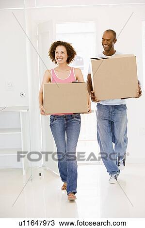 Couple with boxes moving into new home smiling View Large Photo Image Stock Image - Couple with boxes moving into new home smiling. Fotosearch