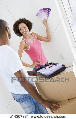 Couple with paint swatches in new home smiling View Large Photo Image Picture - Couple with paint swatches in new home smiling. Fotosearch