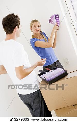 Couple with paint swatches in new home smiling View Large Photo Image Stock Image - Couple with paint swatches in new home smiling. Fotosearch