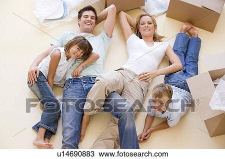Family lying on floor by open boxes in new home smiling View Large Photo Image Stock Image - Family lying on floor by open boxes in new home smiling. Fotosearch