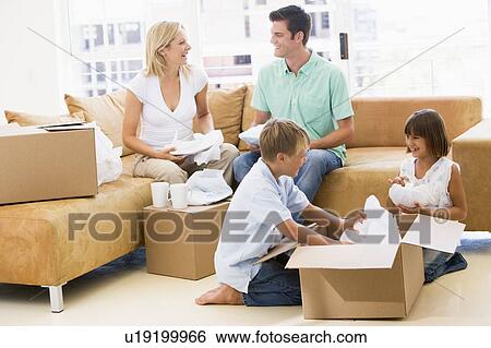 Family unpacking boxes in new home smiling View Large Photo Image Stock Photograph - Family unpacking boxes in new home smiling. Fotosearch