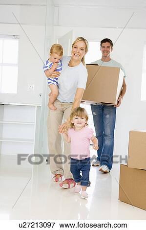 Family with box moving into new home smiling View Large Photo Image Stock Photo - Family with box moving into new home smiling. Fotosearch