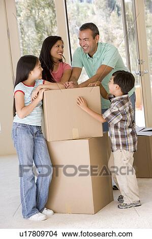 Family with boxes in new home smiling View Large Photo Image Picture - Family with boxes in new home smiling. Fotosearch