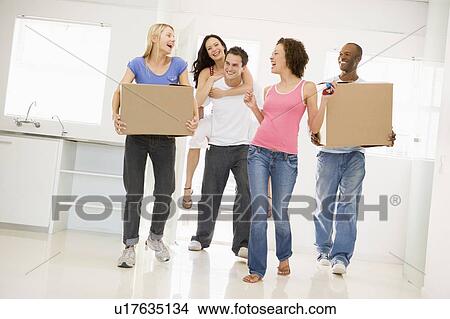 Group of friends moving into new home smiling View Large Photo Image Picture - Group of friends moving into new home smiling. Fotosearch