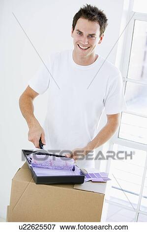 Man painting room in new home smiling View Large Photo Image Stock Photo - Man painting room in new home smiling. Fotosearch