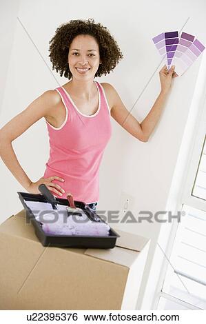 Woman with paint swatches in new home smiling View Large Photo Image Stock Photograph - Woman with paint swatches in new home smiling. Fotosearch