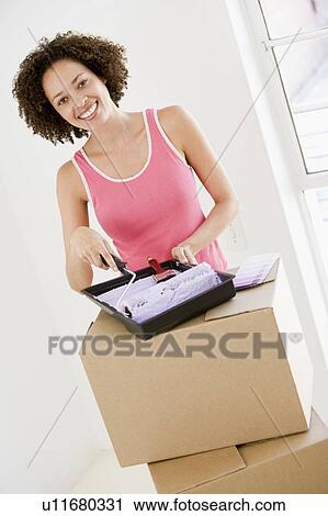 Woman with roller and paint in new home smiling View Large Photo Image Stock Image - Woman with roller and paint in new home smiling. Fotosearch
