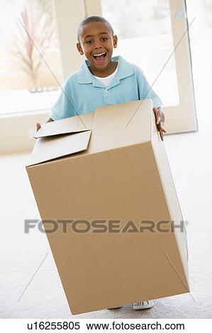 Young boy holding box in new home smiling View Large Photo Image Stock Photography - Young boy holding box in new home smiling. Fotosearch