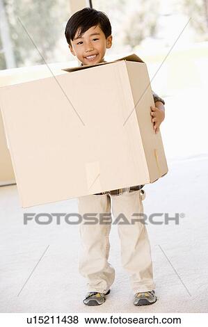 Young boy with box in new home smiling View Large Photo Image Stock Photo - Young boy with box in new home smiling. Fotosearch