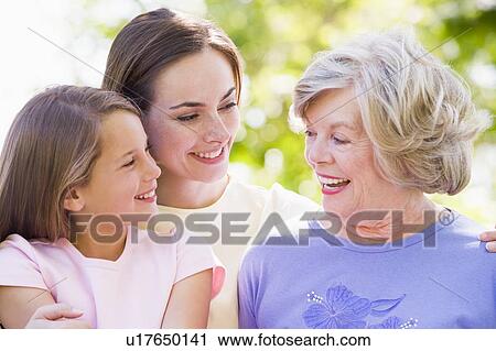 Stock Image - Grandmother with adult daughter and grandchild in park. Fotosearch