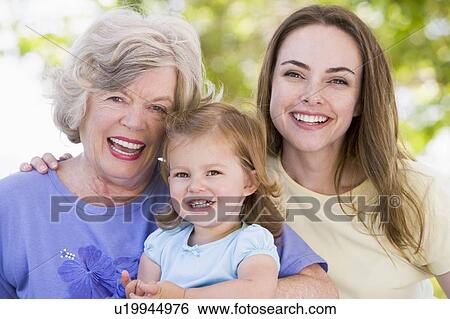 Stock Photograph - Grandmother with adult daughter and grandchild in park. Fotosearch