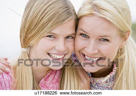 Stock Photograph - Mother and daughter at beach smiling. Fotosearch