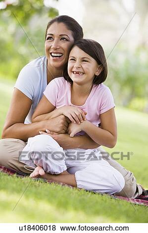 Stock Photo - Mother and daughter outdoors in park smiling (selective focus). Fotosearch