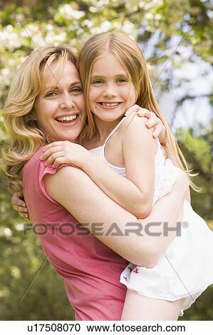 Mother holding daughter outdoors smiling View Large Photo Image Stock Image - Mother holding daughter outdoors smiling. Fotosearch