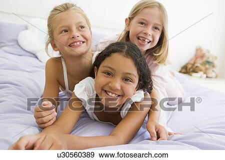 Three Young Girls Lying On Top Of Each Other In Their Pajamas View Large Photo Image Stock Photo - Three Young Girls Lying On Top Of Each Other In Their Pajamas. Fotosearch