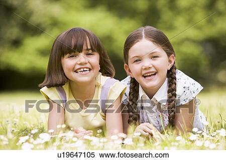 Two sisters lying outdoors smiling View Large Photo Image Stock Photography - Two sisters lying outdoors smiling. Fotosearch