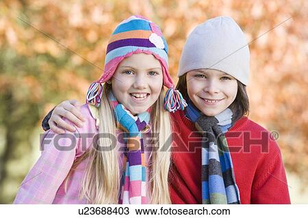 Stock Image - Two young children outdoors in park smiling (selective focus). Fotosearch