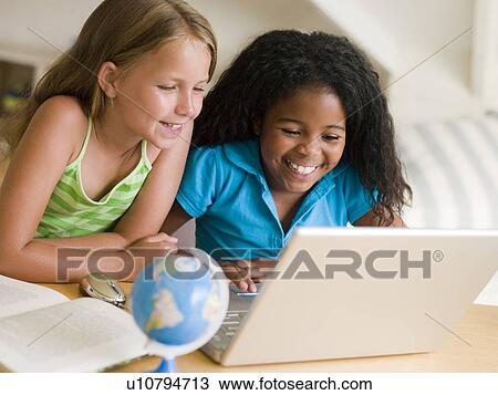 Two Young Girls Doing Their Homework On A Laptop View Large Photo Image Stock Image - Two Young Girls Doing Their Homework On A Laptop. Fotosearch