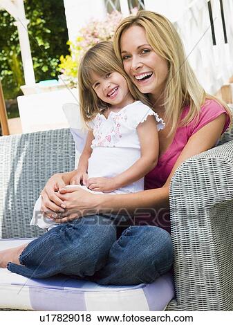 Woman and young girl sitting on patio laughing View Large Photo Image Stock Photo - Woman and young girl sitting on patio laughing. Fotosearch
