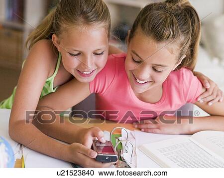 Young Girls Distracted From Their Homework, Playing With A Cellphone View Large Photo Image Stock Image - Young Girls Distracted From Their Homework, Playing With A Cellphone. Fotosearch