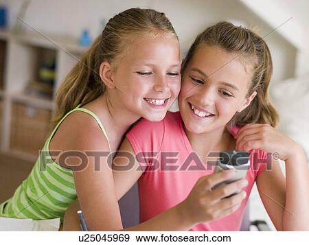 Young Girls Playing With A Cellphone View Large Photo Image Stock Photo - Young Girls Playing With A Cellphone. Fotosearch