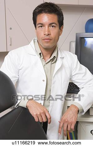 Stock Photo - A Doctor Standing By A Computer Monitor. Fotosearch