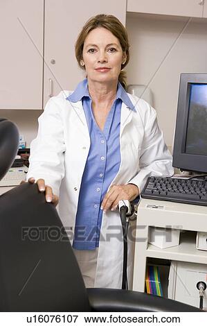 Stock Photo - A Doctor Standing By A Computer Monitor. Fotosearch