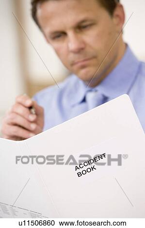 Businessman indoors looking at Accident Book View Large Photo Image Stock Image - Businessman indoors looking at Accident Book. Fotosearch