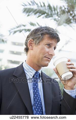 Businessman outdoors drinking coffee View Large Photo Image Stock Photo - Businessman outdoors drinking coffee. Fotosearch