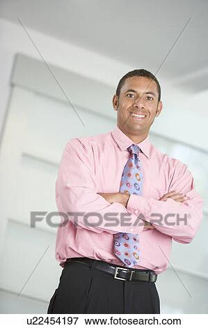 Stock Photo - Businessman standing indoors smiling. Fotosearch