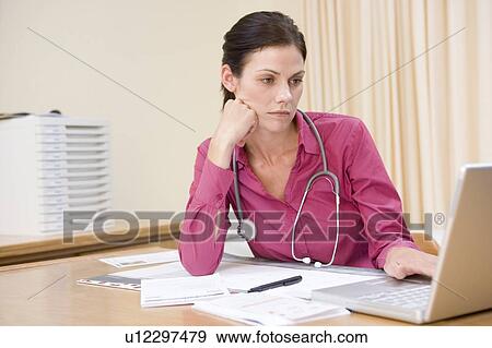 Doctor using laptop in doctor's office View Large Photo Image Stock Photo - Doctor using laptop in doctor's office. Fotosearch
