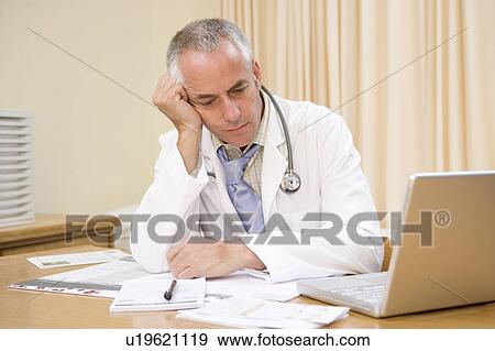 Stock Photo - Doctor with laptop in doctor's office. Fotosearch