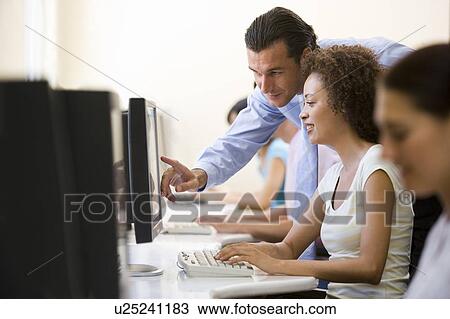 Man assisting woman in computer room View Large Photo Image Stock Image - Man assisting woman in computer room. Fotosearch