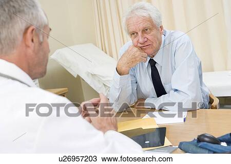 Man in doctor's office frowning View Large Photo Image Stock Image - Man in doctor's office frowning. Fotosearch