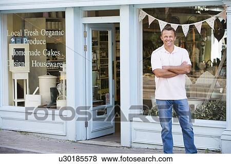Man standing in front of organic food store smiling View Large Photo Image Stock Photo - Man standing in front of organic food store smiling. Fotosearch