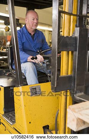 Stock Photograph - Warehouse worker in forklift. Fotosearch