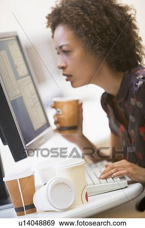 Stock Photo - Woman in computer room with many cups of empty coffee around her. Fotosearch