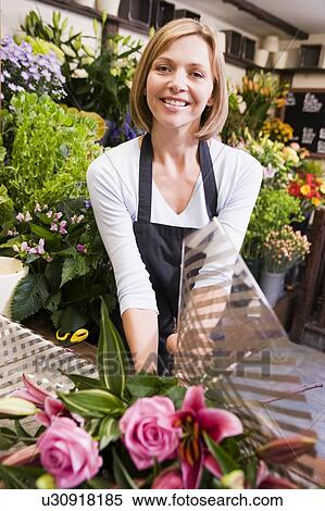 Woman working at flower shop smiling View Large Photo Image Stock Photography - Woman working at flower shop smiling. Fotosearch