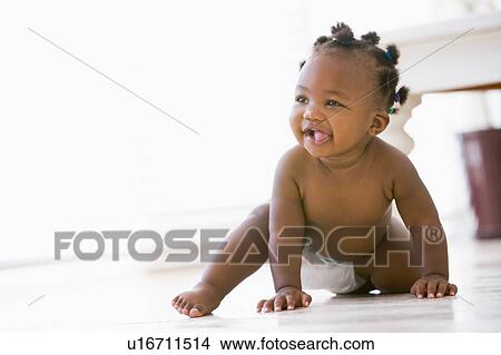 Picture - Baby crawling indoors smiling. Fotosearch