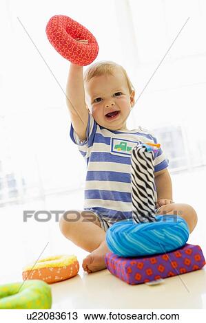 Baby indoors playing with soft toy View Large Photo Image Stock Image - Baby indoors playing with soft toy. Fotosearch