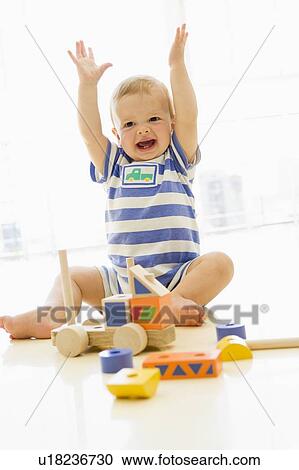 Baby indoors playing with truck View Large Photo Image Stock Image - Baby indoors playing with truck. Fotosearch