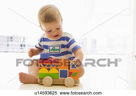 Stock Photography - Baby indoors playing with truck. Fotosearch