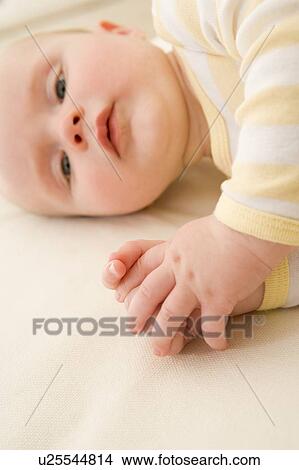 Picture - Baby lying indoors. Fotosearch