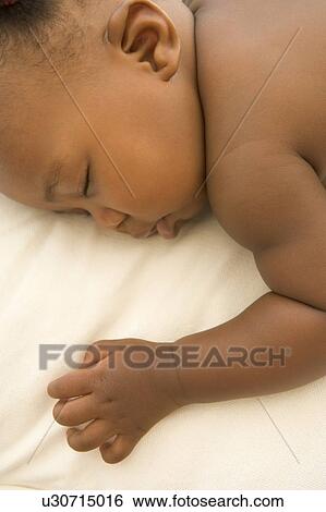 Baby lying indoors sleeping View Large Photo Image Stock Photograph - Baby lying indoors sleeping. Fotosearch