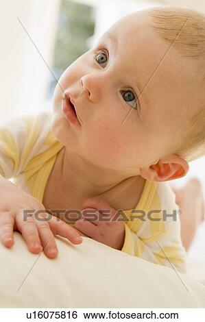 Stock Photograph - Baby lying indoors. Fotosearch