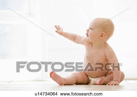 Picture - Baby sitting indoors. Fotosearch