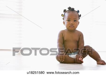 Stock Image - Baby sitting indoors. Fotosearch