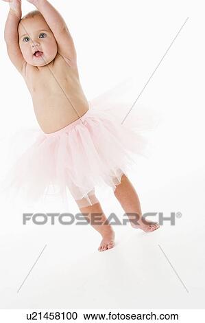 Stock Image - Baby standing in tutu. Fotosearch