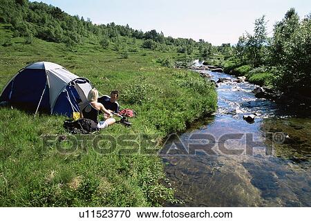 Couple outdoors at campsite talking and smiling View Large Photo Image Stock Image - Couple outdoors at campsite talking and smiling. Fotosearch
