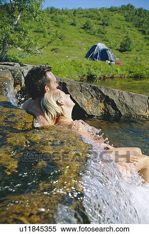 Couple outdoors by campsite relaxing in stream View Large Photo Image Stock Photography - Couple outdoors by campsite relaxing in stream. Fotosearch